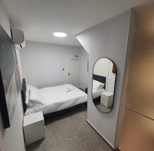 a small room with a bed and a mirror at דירת נופש מושלמת 5 דקות מחוף הים Ryo 31 in Bat Yam