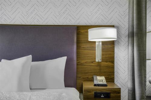 a bedroom with a bed and a lamp on a night stand at Home2 Suites By Hilton St. Simons Island in Saint Simons Island