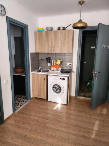 a kitchen with a stove and a washing machine at Bakuriani Art Hotel apartament in Bakuriani