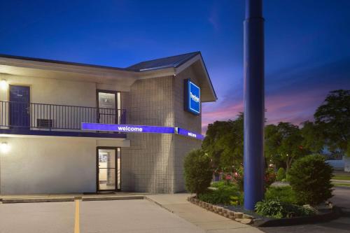 a building with a light pole in front of it at Travelodge by Wyndham Madison Heights MI in Madison Heights