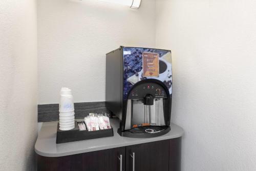 a coffee maker and a box on a shelf at Travelodge by Wyndham Madison Heights MI in Madison Heights