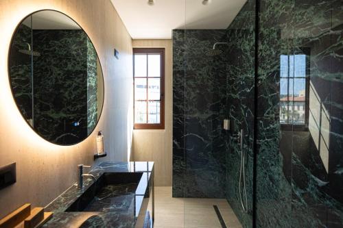 a bathroom with a large mirror and a sink at Sazani Hotel in Vlorë