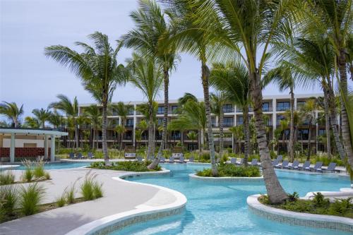 a resort with palm trees and a swimming pool at Zemi Miches Punta Cana All-Inclusive Resort, Curio by Hilton in Miches