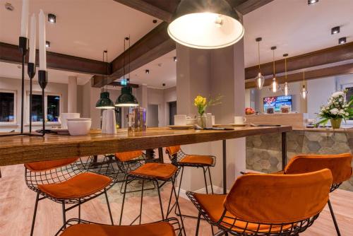 a bar with chairs and a counter in a room at Vienna House Easy by Wyndham Ingolstadt in Ingolstadt