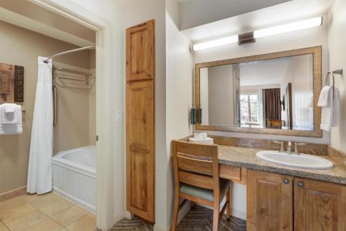 a bathroom with a sink and a mirror and a tub at Hilton Vacation Club Villas de Santa Fe in Santa Fe
