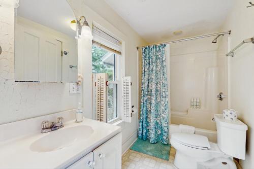 a bathroom with a toilet and a sink and a window at Gingerbread Dream in Oak Bluffs