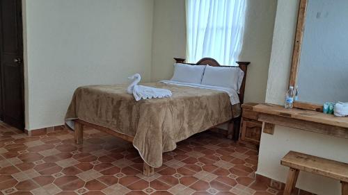 サン・ミゲル・レグラにあるHotel Renacerのベッドルーム1室(白鳥のベッド1台付)
