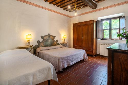 a bedroom with two beds and two lamps in it at Tenuta di Corsano in Monteroni dʼArbia