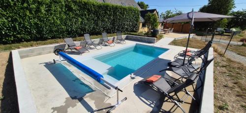 a swimming pool with chairs and a blue inflatable at Brocéliande calme breton, spa, wifi, amazon-disney tv, 4 lits, Freebox revolution,draps, café, thé in Guer