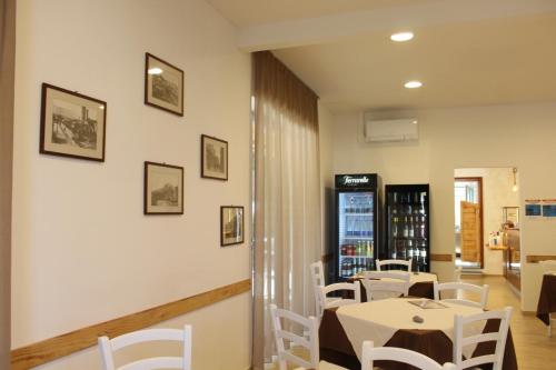 a dining room with white tables and white chairs at Hotel Ristorante La Collina in Imola