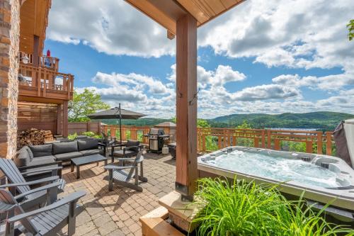 a patio with a hot tub on a deck at Tremblant Prestige - Altitude 170-2 in Mont-Tremblant