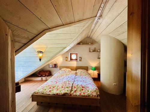 a bedroom with a large bed in a attic at Les Ecuries du Lac in Weywertz