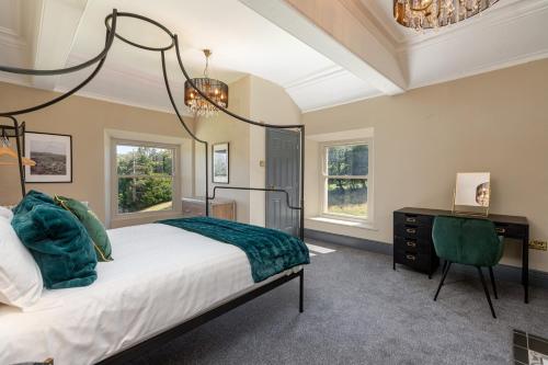 a bedroom with a bed and a desk and windows at The Scarborough Suite in Marske