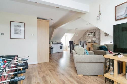 a living room with a couch and a tv at The Penthouse at Beach Court in Trearddur