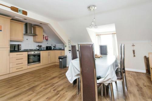 a kitchen with a table with a white table cloth at The Penthouse at Beach Court in Trearddur