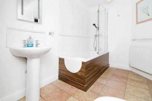 a bathroom with a sink and a bath tub at The Penthouse at Beach Court in Trearddur