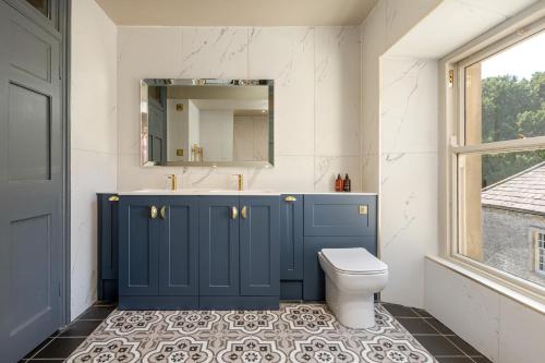 a bathroom with a blue cabinet and a toilet at The Scarborough Suite in Marske