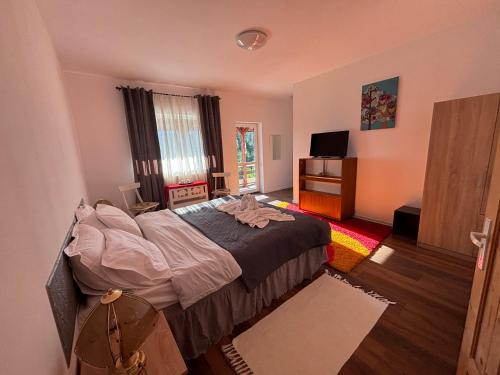 a bedroom with a large bed and a television at Weinesya Sunset Smida in Beliş