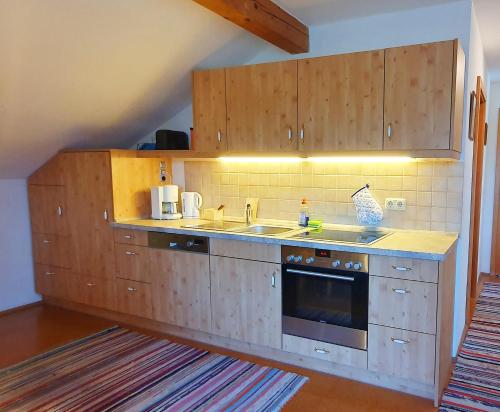 a kitchen with wooden cabinets and a sink at Hechlhof in Seeon-Seebruck