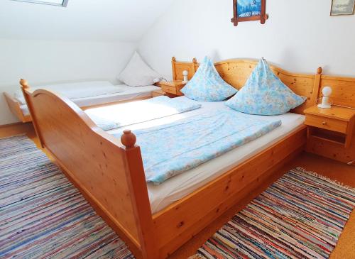 a wooden bed with blue pillows in a room at Hechlhof in Seeon-Seebruck