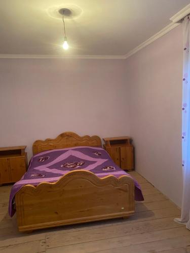 a bedroom with a bed with a purple blanket on it at Zuriko Kakhiani's Guest House in Zhabeshi