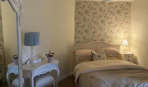 a bedroom with a bed and a lamp on a table at 11 George Street Doune in Stirling