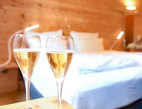 two glasses of champagne on a table next to a bed at Villa Shoda in Oni