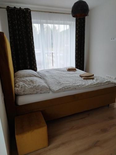a bed in a room with a window at Brezovina Apartman 102 in Veselé