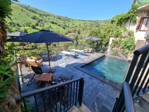 une maison avec une piscine entourée d'un parasol dans l'établissement Au coeur du Village de Lucciana, à Lucciana
