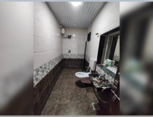 a bathroom with a sink and a toilet and a mirror at Luxury villa in Mumbai