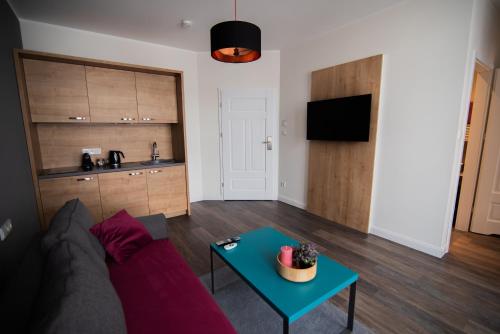 a living room with a couch and a table at Apartamenty Polonia Mrągowo in Mrągowo