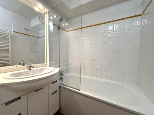 La salle de bains blanche est pourvue d'un lavabo et d'une baignoire. dans l'établissement Appartement cosy avec balcon, au pied des pistes, piscine, parking, à Flumet - FR-1-505-110, à Flumet