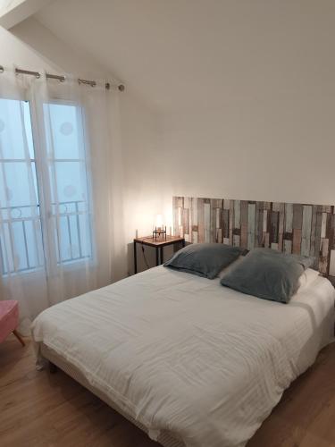 a bedroom with a large white bed with two pillows at Maison Hendaye Plage in Hendaye