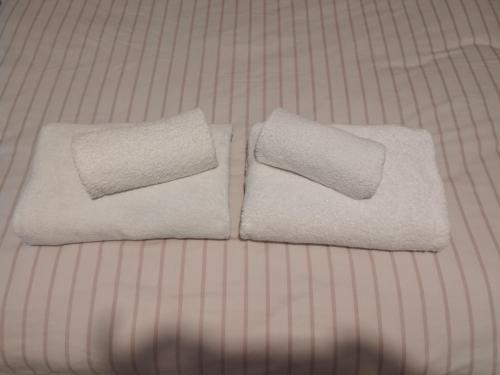 two towels sitting on top of a bed at Knightstown Apartment in Valentia Island