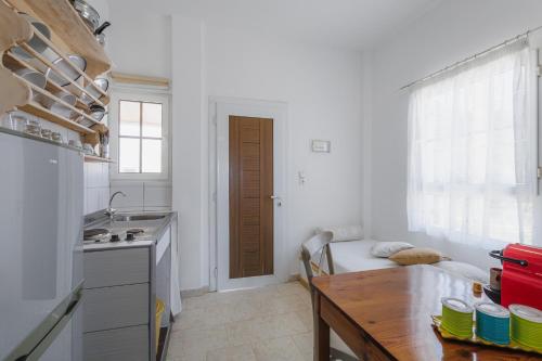 a kitchen with a table and a sink and a door at Studios Eliza in Livadion