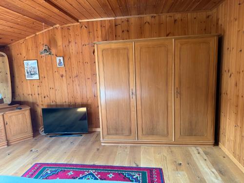 a living room with wooden cabinets and a tv at Casa Walser Quarten - CharmingStay in Quarten