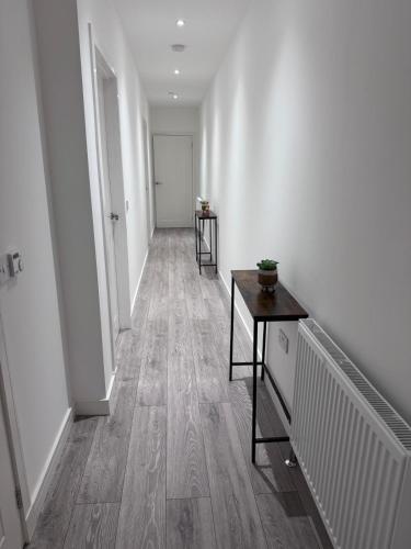 an empty hallway with a table and a door at Ash Residence - Lovely 2 spacious bedrooms city centre flat with private parking in Aberdeen