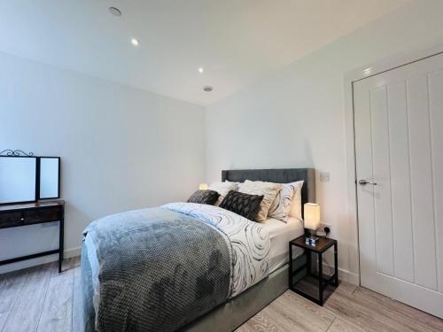a white bedroom with a bed and a television at Ash Residence - Lovely 2 spacious bedrooms city centre flat with private parking in Aberdeen