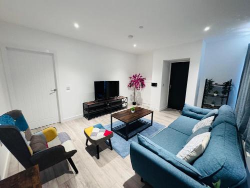 a living room with a blue couch and chairs at Ash Residence - Lovely 2 spacious bedrooms city centre flat with private parking in Aberdeen