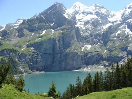 a mountain with a blue lake in front of it at Hotel Altels in Kandergrund