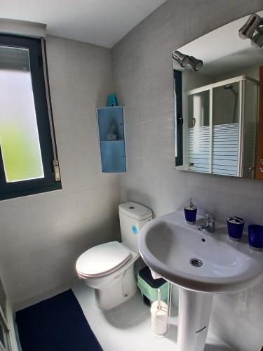 a bathroom with a white toilet and a sink at Tikitita House in Gandía