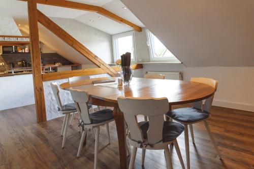 a dining room with a wooden table and chairs at 100 qm DG Wohnung 《Kehr wieder》Bexbach Saarland in Bexbach