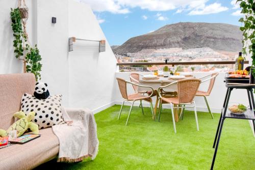 un balcon avec de l'herbe verte et une table et des chaises dans l'établissement SEA VIEW, 5min BEACH, WiFi, POOL, CITY CENTER, DOLPHIN EXCURSIONS, KIDS FRIENDLY, à Los Cristianos