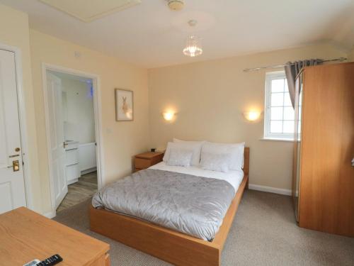 une petite chambre avec un lit et une fenêtre dans l'établissement Midsummer Cottage, à Wilton