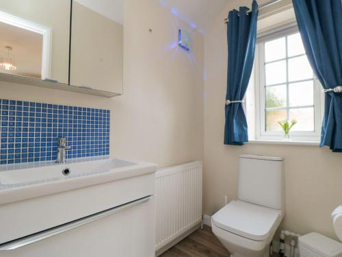 une salle de bain avec toilettes, lavabo et fenêtre dans l'établissement Midsummer Cottage, à Wilton