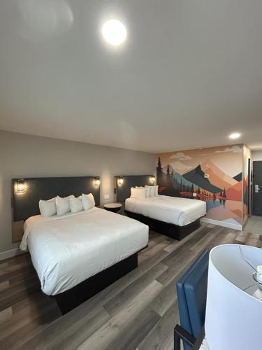 a hotel room with two beds and a painting on the wall at Hotel Elev8 Flagstaff, Trademark Collection by Wyndham in Flagstaff