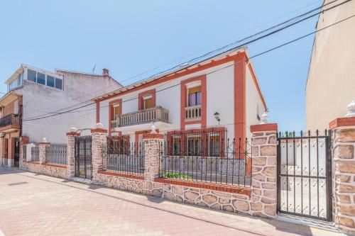 a brick house with a fence on a street at El Cortijo de Palma in Villarejo de Salvanés