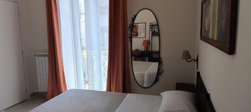 a bedroom with a mirror and a bed and a window at Misciù in Naples