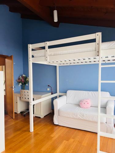 a bedroom with a bunk bed and a white couch at Asturias La Casa Azul in Sobrepiedra