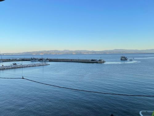 a large body of water with a pier and boats at Delfinia Studios in Platanias